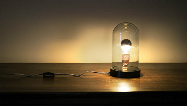Lampe sous cloche sur une commode en bois